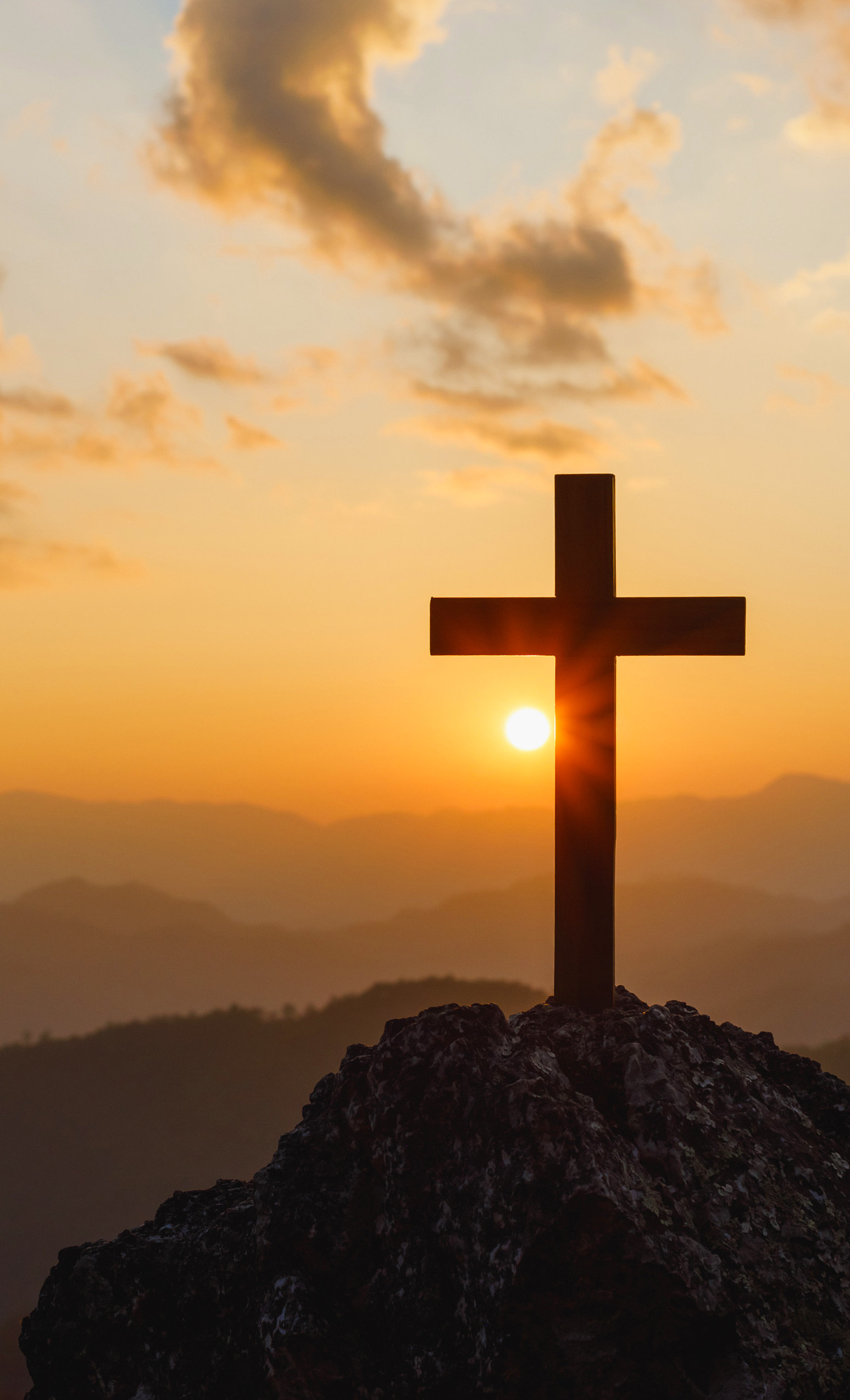 Cross on hilltop at sunrise